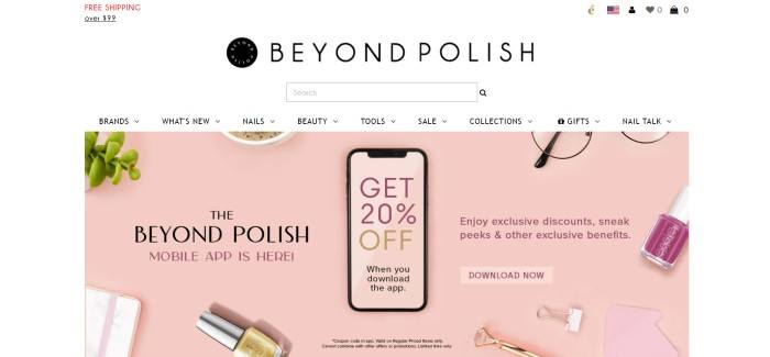 This screenshot of the home page for Beyond Polish has a white background, black text in the header and navigation bar, and a large pink-background overhead photo showing a mobile device with the Beyond Polish shopping app on its screen, as well as partial images around it that include a green plant, a cup of coffee, glasses, paper clips, and nail polish, as well as black and purple text and a purple call to action button.