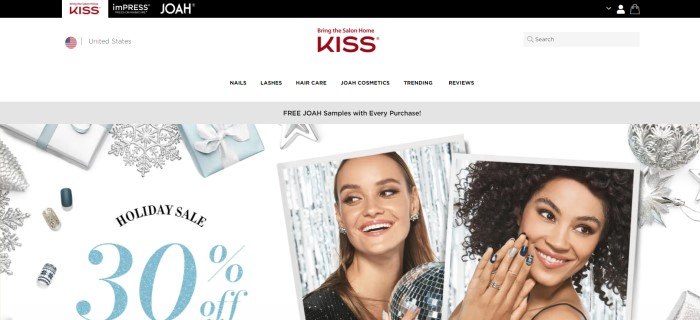 This screenshot of the home page for Kiss has a black header, a white navigation bar, a gray announcement bar, and a main section with a white background, silver snowflakes, white and blue wrapped gifts, two photo inserts showing smiling women with beautiful decorated nails, and black and blue text.