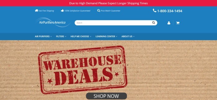 This screenshot of the home page for Air Purifiers America has a red header, a blue header, and a blue navigation bar with white text above a closeup photo of a piece of corrugated cardboard with a red stamped announcement for warehouse deals on it, along with a black call to action button.