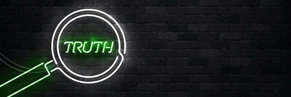 black brick wall with neon text "truth"