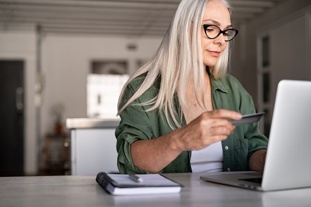 older woman using credit card to shop online