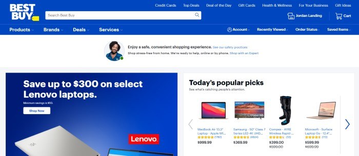 This screenshot of the home page for Best Buy has a blue and white header, navigation bar, and search bar above a white main section that includes an announcement bar with a photo of a smiling dark haired woman, a blue and white text section with a white call to action button on the left side of the page, and a white section with a row of small product photos and descriptive text in black on the right side of the page.