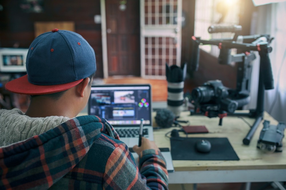 young man working in youtube studio with mic, dslr camera, and video editing software