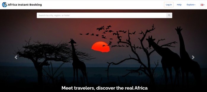 This screenshot of the home page for Africa Instant Booking has a white header, a search bar, and a large photo showing the silhouettes of giraffes and flying birds near two trees on a savannah, with a large red sun in the background.