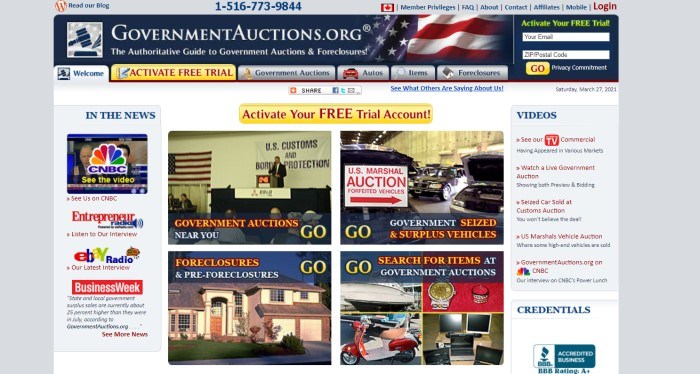 This screenshot of the home page for GovernmentAuctions.org has a gray surrounding section, a blue header with a flag photo faded into it, a gray and gold navigation bar, and a white main section containing media inclusions on the left side of the page, video links on the right side of the page, and four pictures in the center of the page depicting auction scenes for a variety of goods, as well as a gold call to action button.