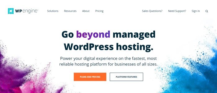 This screenshot of the home page for WP Engine has a white navigation bar and main section with black and purple text, a white and an orange call to action button, purple paint splashes in the lower left corner, and blue paint splashes in the lower right corner of the page.