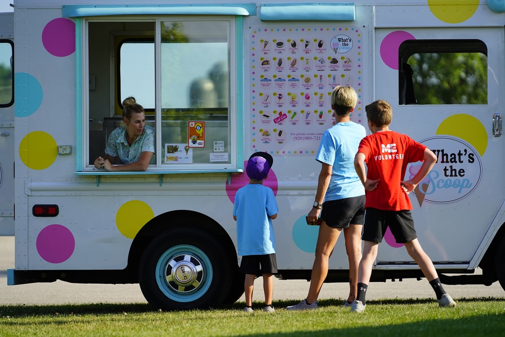 Family and kids buying ice cream and treats from a ice cream truck.