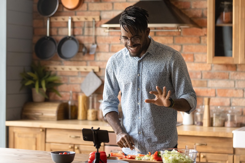 A man prepares a cheese dish in his kitchen.