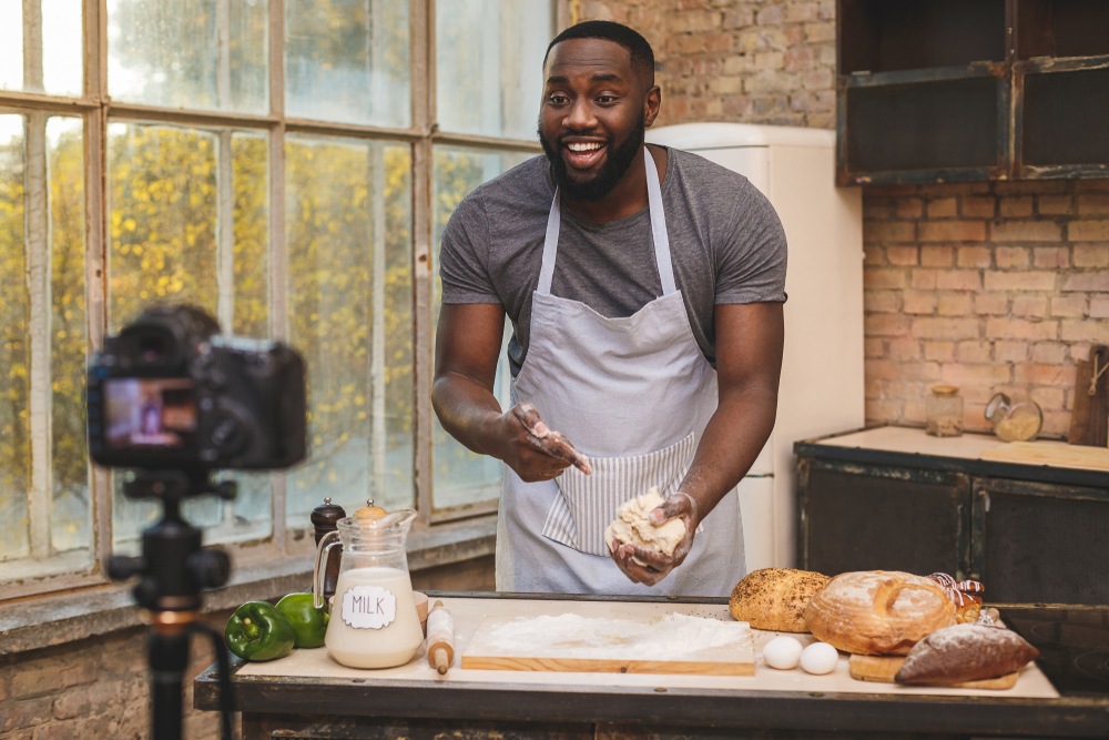 A man films himself making bread. 