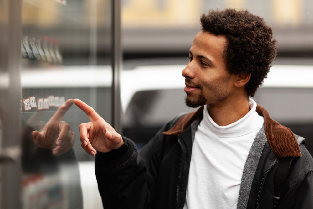 A man points at different items in a vending machine.