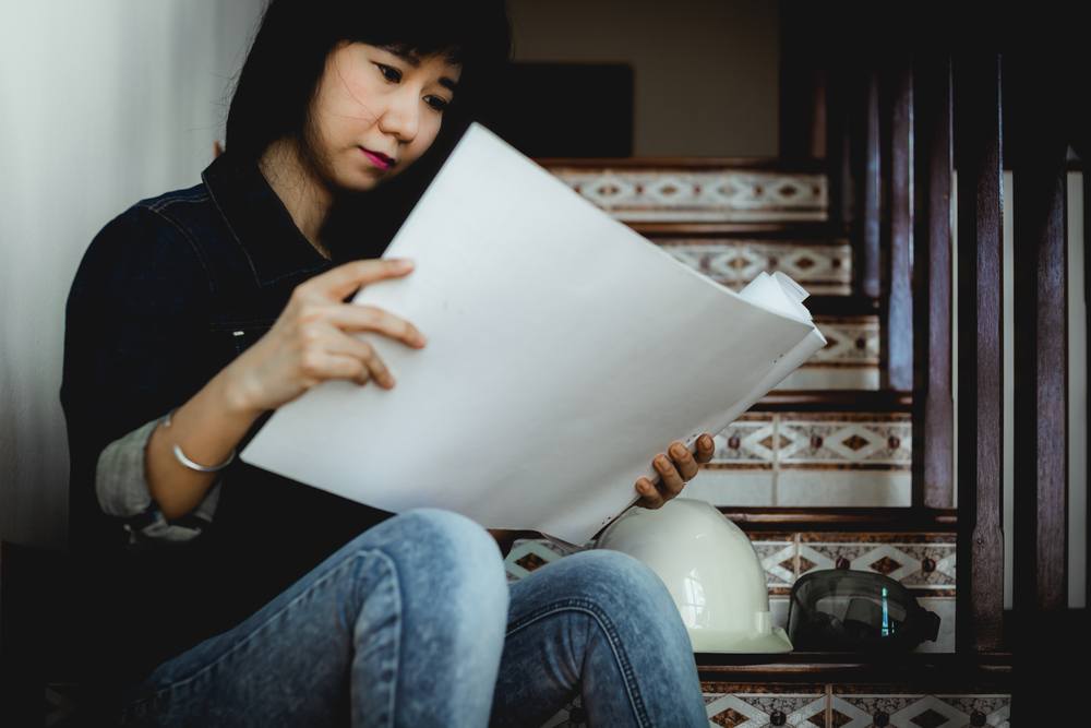 A woman consults the blueprint of a home.