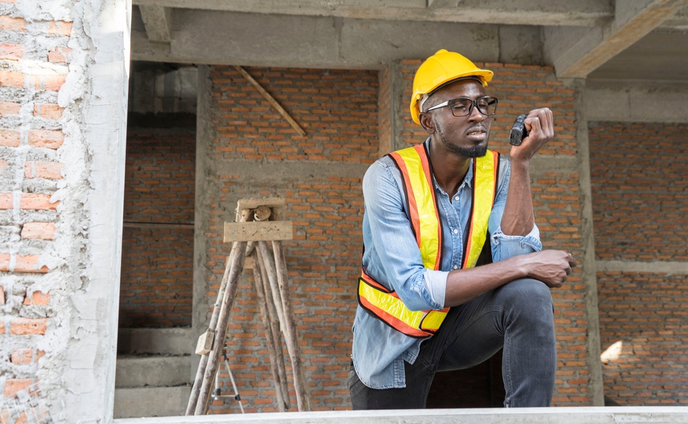 A man in a hardhat takes a measurement.