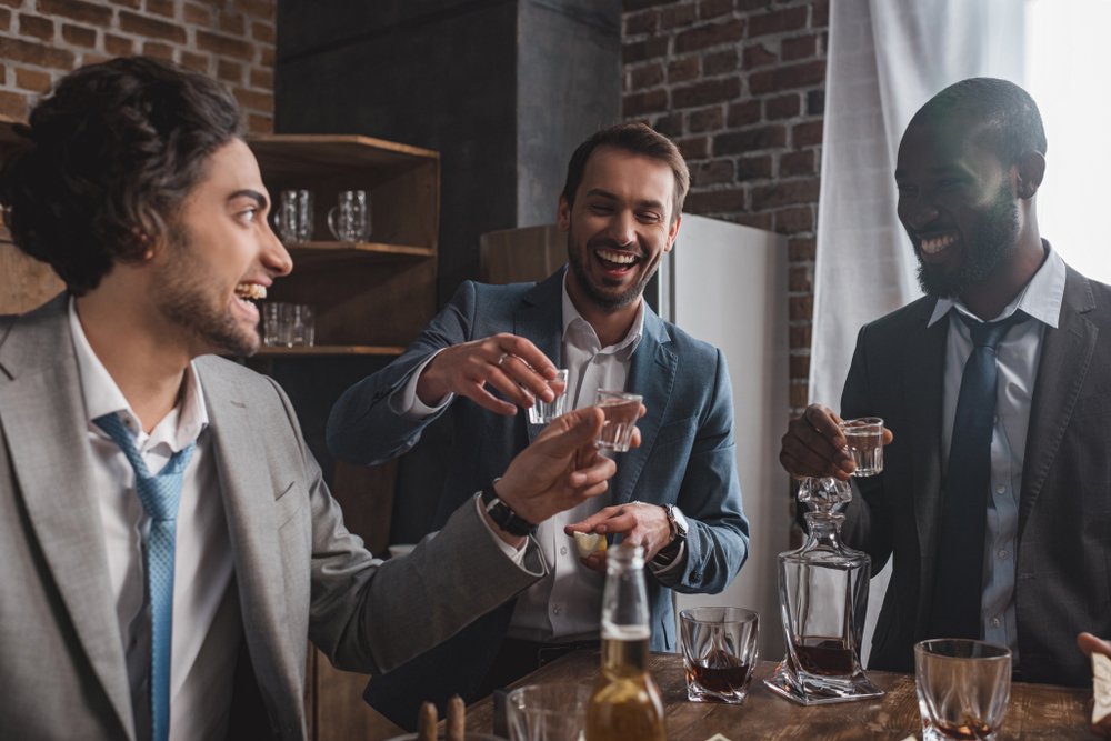 Three friends toast with glasses of craft tequila. 