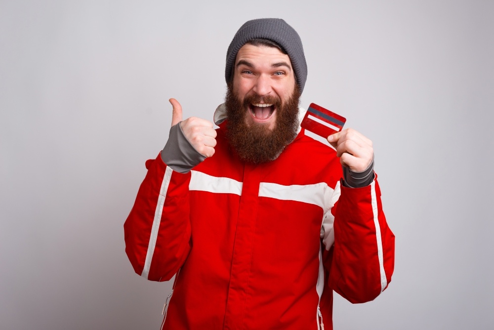 Man smiling while holding a gift card