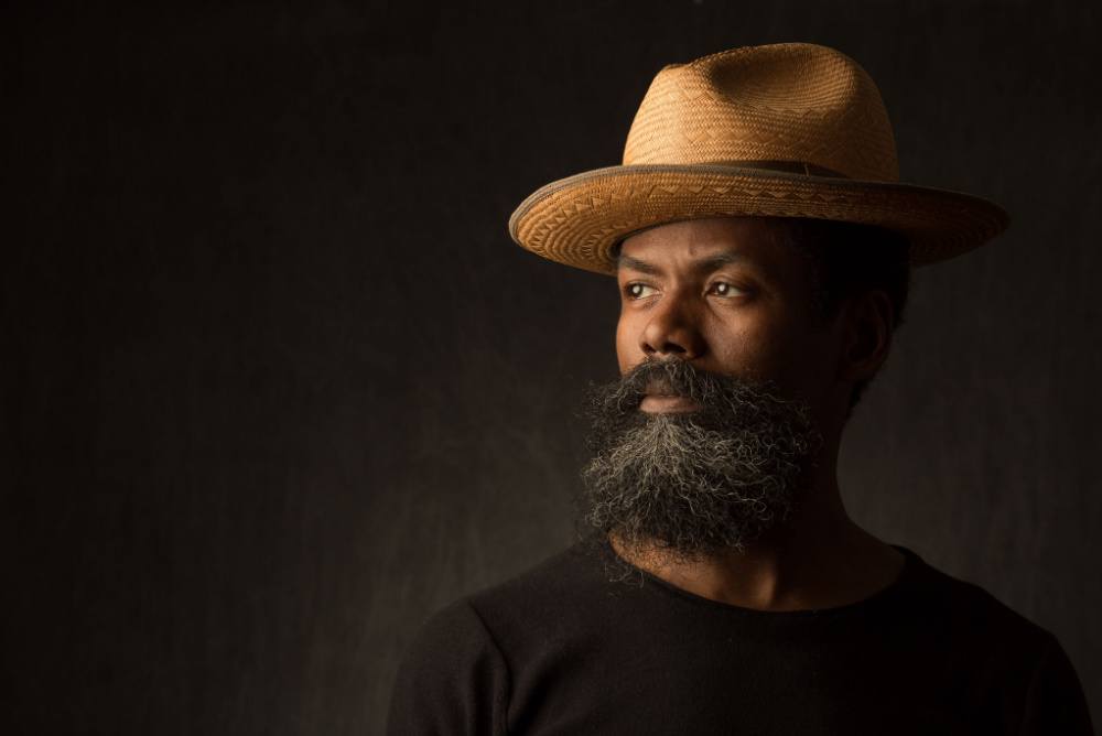 middle-age black man wearing a stylish hat with large black and grey beard