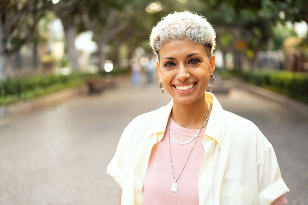 young lgbt woman with frosted tips hair wearing earrings and necklace