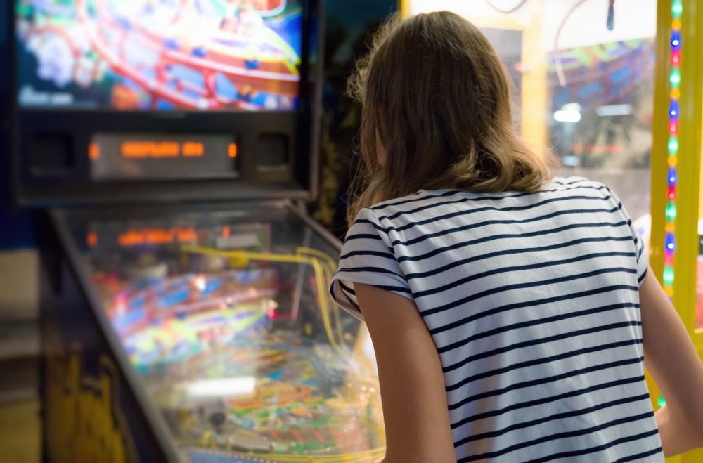 Woman playing on a pinball machine