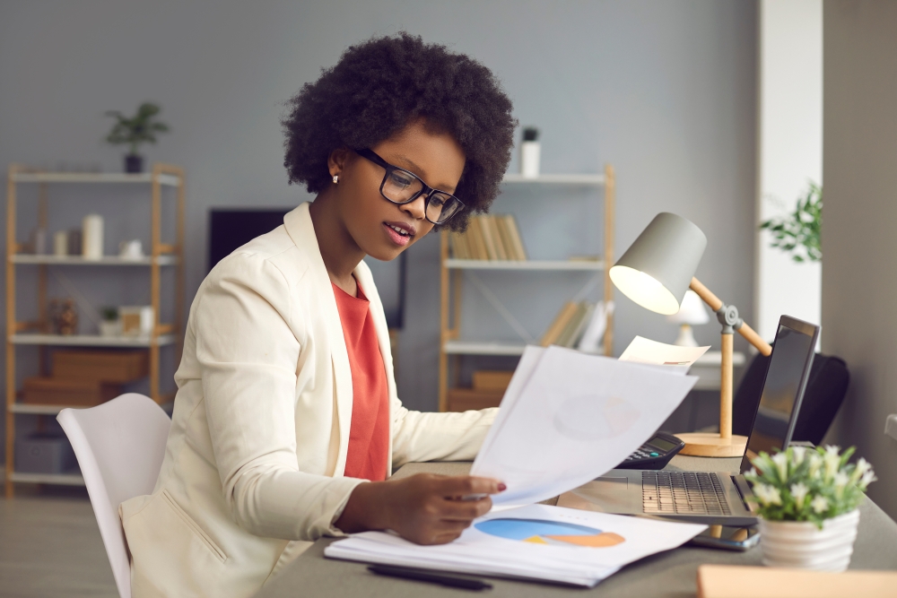 black woman reading financial report with pie chart