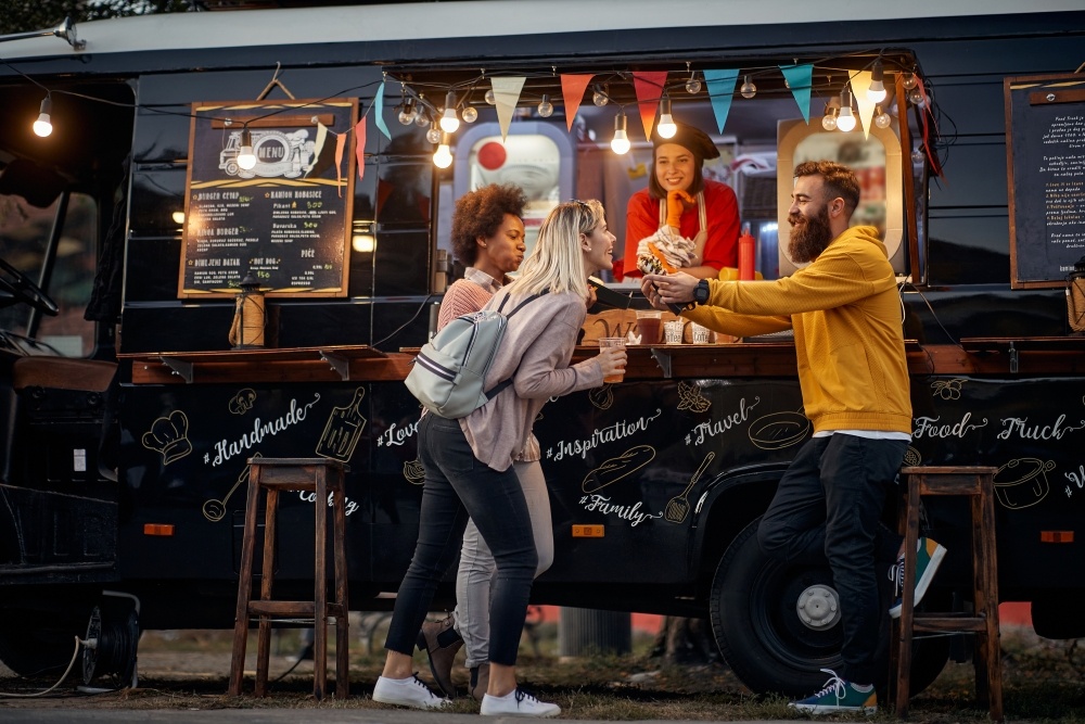 group of young people eating at a food truck