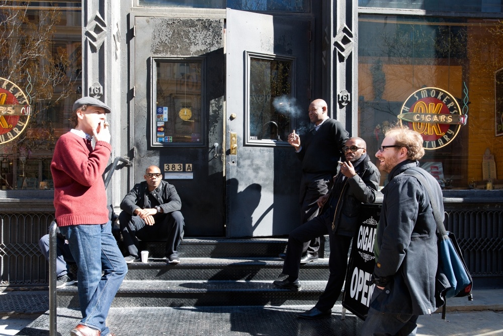 People gathered in front of a smoke shop